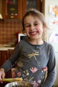 Portrait of cute girl standing at home