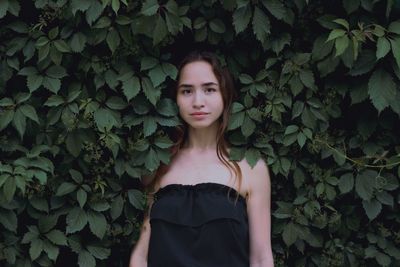 Portrait of beautiful woman standing amidst plants