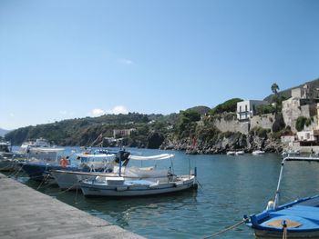 Sailboats moored on sea against clear sky