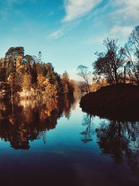 Reflection of trees in lake against sky