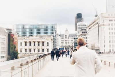 Rear view of business people walking in front of buildings 