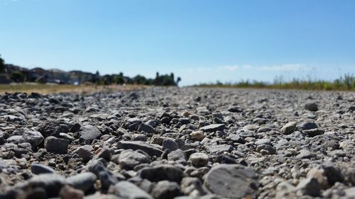 Surface level of stones on landscape against clear sky