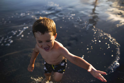 High angle view of boy playing in sea