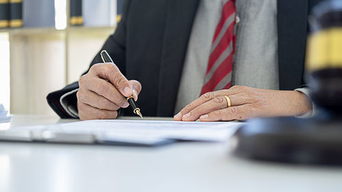 Midsection of man with umbrella on table