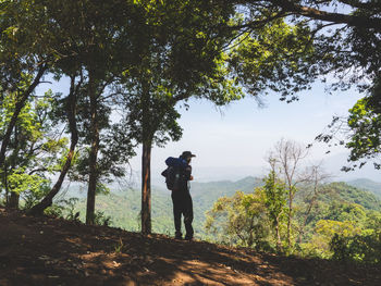 Trekking solo backpack on mountain trail in tropical forest at tak province, thailand.