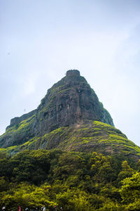 Low angle view of rocks on mountain against sky