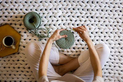 Low section of woman doing crocheting at home