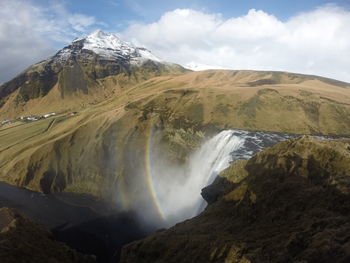Scenic view of waterfall against sky