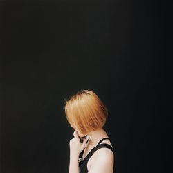 Side view of woman against black background