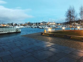 View of illuminated city by street against sky