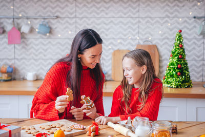 Mother and daughter preparing gingerbread cookies at home