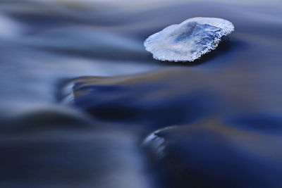 Ice on a smooth rock in river.