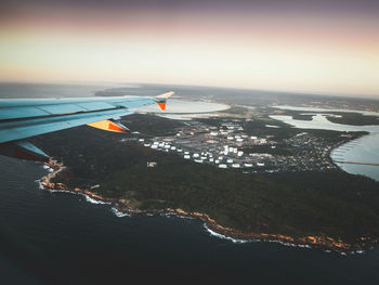 Airplane flying over sea against sky