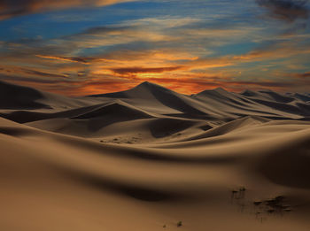 Scenic view of desert against sky during sunset
