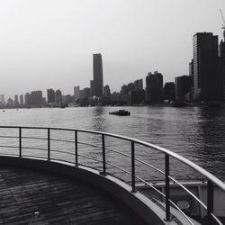 City skyline by river against sky