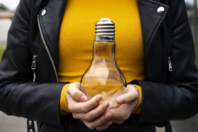 Close-up of man holding yellow camera