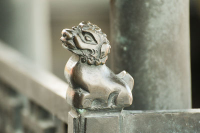 Close-up of animal statue on railing