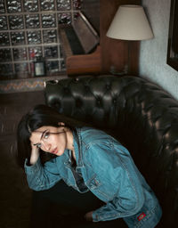 Side view of young woman sitting on a couch