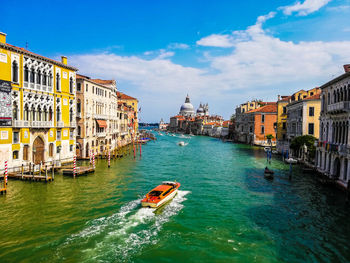 Boats in canal amidst buildings in city