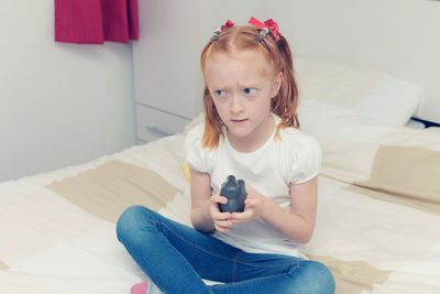 Girl sitting on bed at home