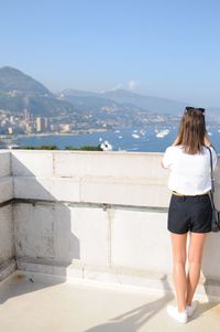 Rear view of woman looking at sea against sky