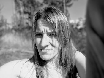 Portrait of woman with brown hair standing against sky