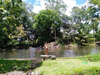 Scenic view of river by trees against sky