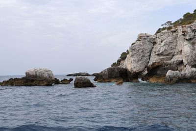 Scenic view of rocks in sea against sky