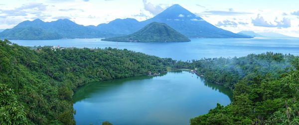 Scenic view of sea and mountains against sky