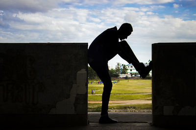 Side view of silhouette man standing against sky