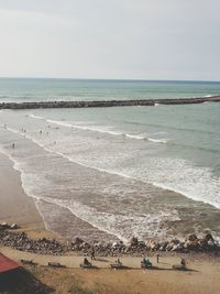 People at beach against sky