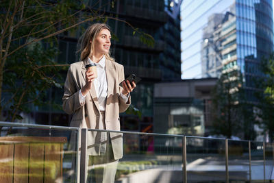 Portrait of young businesswoman standing in city