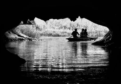 Silhouette people in water against sky
