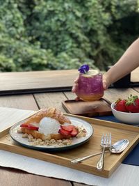 Midsection of woman eating food in plate on table