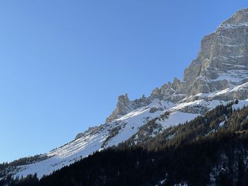 Scenic view of snowcapped mountains against clear blue sky