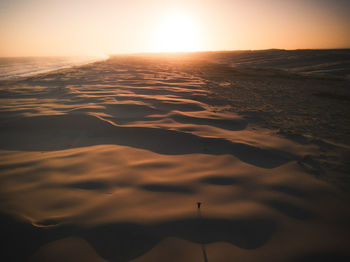 Scenic view of beach against clear sky during sunset