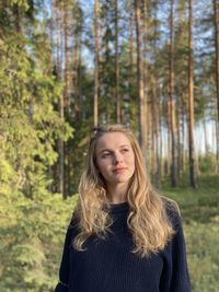 Portrait of young woman standing in forest