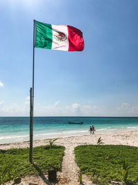 Flags on beach against sky