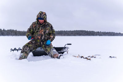 Man in snow against sky during winter