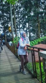 Woman walking on footbridge in park