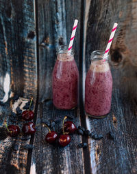 Homemade smoothie of fresh summer berries in glass bottles with paper tubes. 