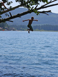 Silhouette of woman jumping in water