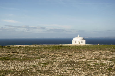 Church by sea against sky