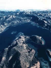 Aerial view of sea and mountains against sky