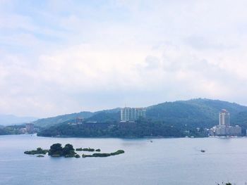 Scenic view of sea and cityscape against sky