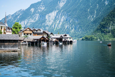 Houses by river and buildings against mountains