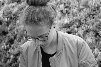 Close-up of young woman standing against plants