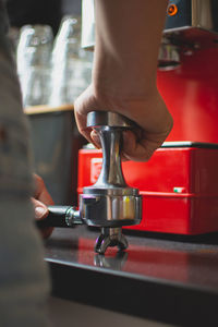 Cropped image of man pressing coffee in portafilter