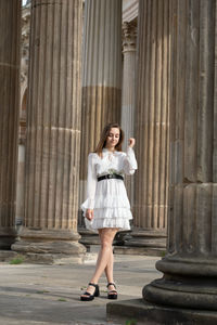 Full length of woman standing against building