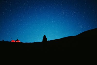 Silhouette mountains against clear blue sky at night